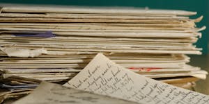 Close-up image of handwritten letters and papers stacked together, conveying a vintage feel.