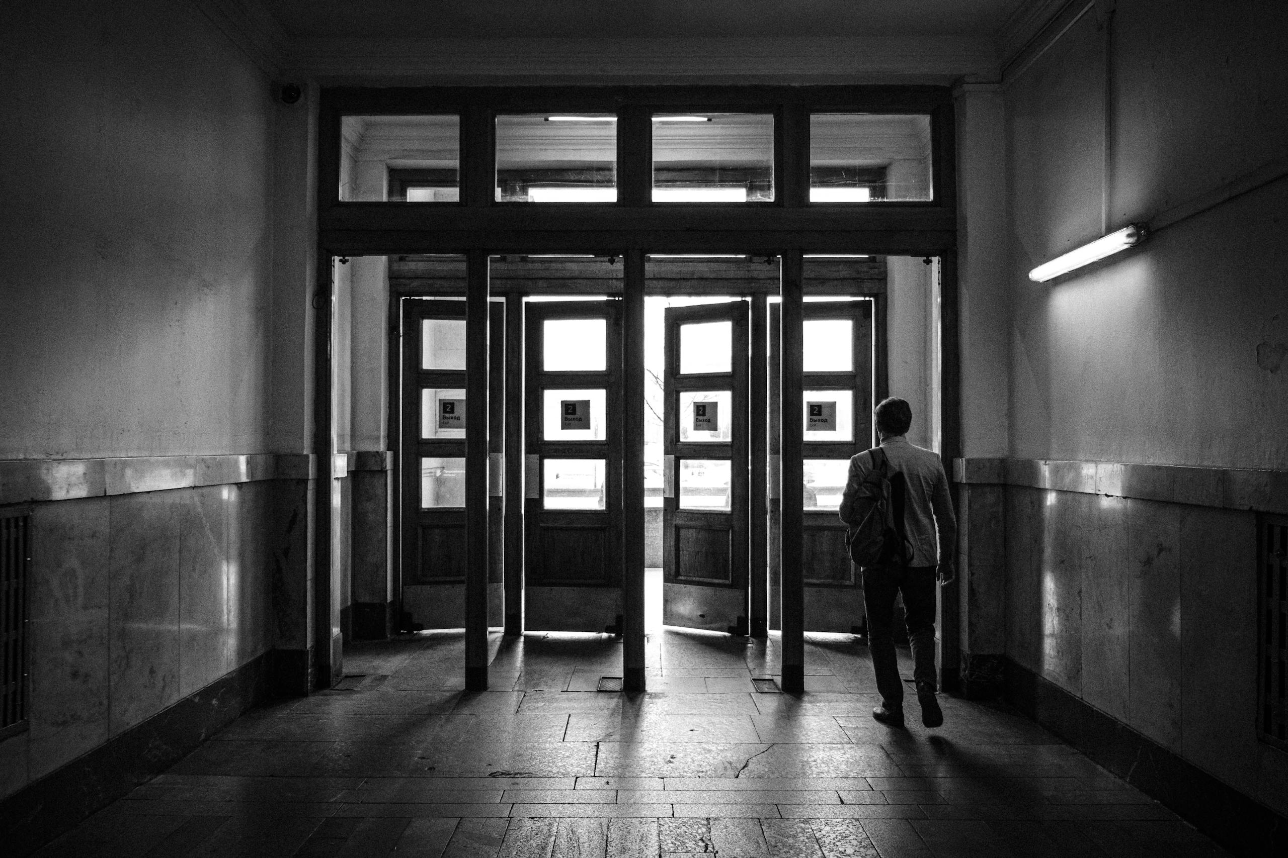 Man walking through historic doorways in Moscow. Black and white photo.
